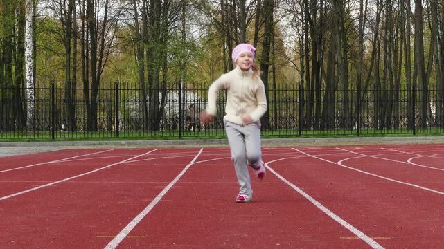 Little girl running on path in stadium