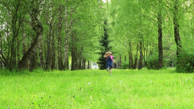 Little girl running on green grass