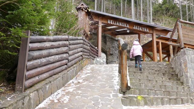 Little beautiful girl walks near Belianska Cave, is stalactite cave in Slovak part of Tatra mountains, largest and only one open to public in Tatras. Vysoke Tatry, Tatranska Kotlina, Lendak, Slovakia.