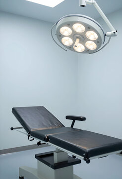 Healthcare and medical examination room, empty patient bed with surgical light in modern hospital clinic