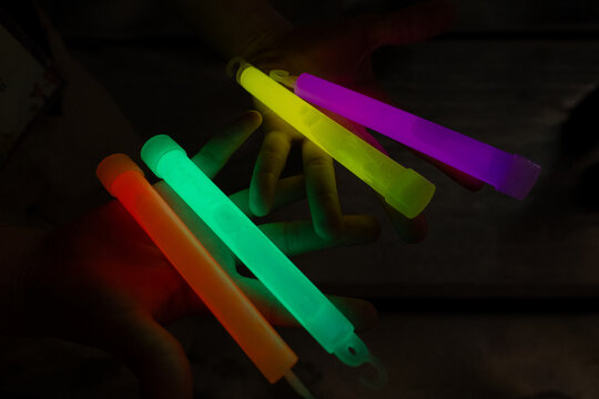 Colorful glowing light sticks held in hands during a night festival in South Korea
