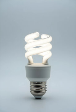 Energy efficiency and sustainability concept, glowing compact fluorescent light bulb on a clean white background