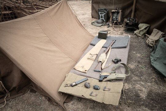 WW2 era ammunition and hand grenades seen on a camp bed at a forward command centre in Europe. Radio gear can be seen on the background.