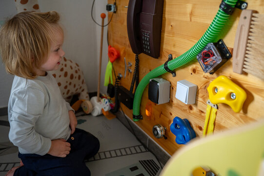 Toddler Exploring a Sensory Board with Real-Life Objects &ndash; Montessori-Inspired Learning, Fine Motor Skills and Child Development
