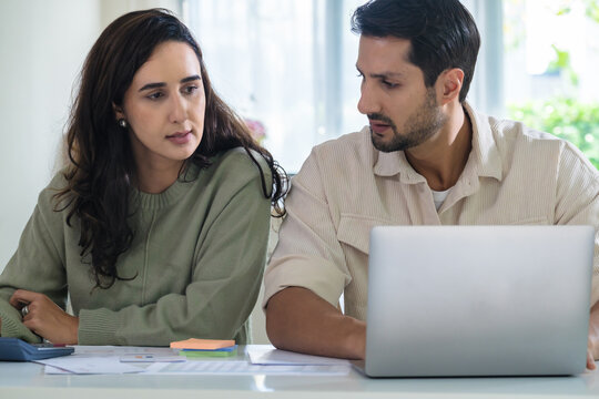 Couple budgeting and calculating tax with laptop at home, managing finance and planning for longterm investment