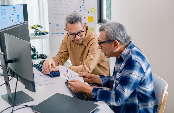 Group of asian senior in a collaborative software development analyzing  flowcharts  during a bootcamp training