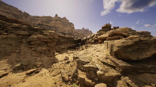 sunlit sandstone canyon under clear sky revealing layered rock formations and rugged terrain, ideal for geology fieldwork, drone photography, adventure hiking