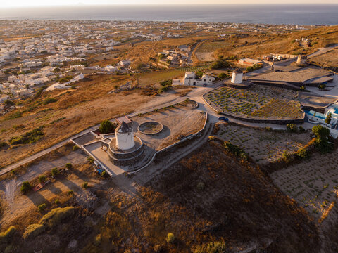 Aerial drone view of traditional whitewashed windmills on Gavrilos Hill overlooking Emporio village in Santorini