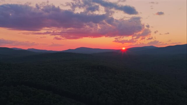 Adirondack Mountain layers Schroon Lake vibrant sunset golden hour red fire sun on horizon clouds New York State aerial drone high peaks layers Mount Severance Pharaoh Lake Wilderness forward pan pano