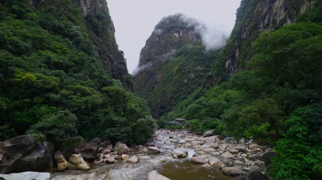 Urabumba river Machu Picchu Aguas Calientes dry rainy season mist clouds Peru high flow brown water jungle hillside Peruvian Andes Mountains lower highlands Inca trail citadel nature landscape static
