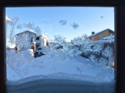 Cristalli di brina e ghiaccio sul vetro di una finestra in inverno