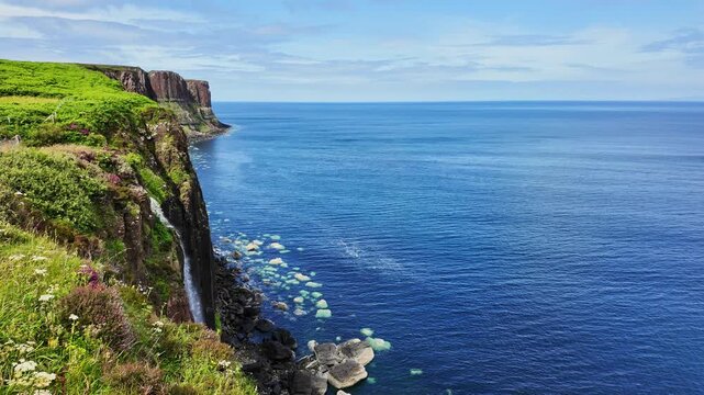 Beautiful view of the cliffs of Kilt Rock with the iconic waterfall in the Isle of Skye, Scotland on a sunny, summer day