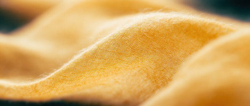 golden linen fabric texture macro closeup warm amber woven cloth background for sustainable wellness branding web design advertising packaging editorial natural organic backdrop
