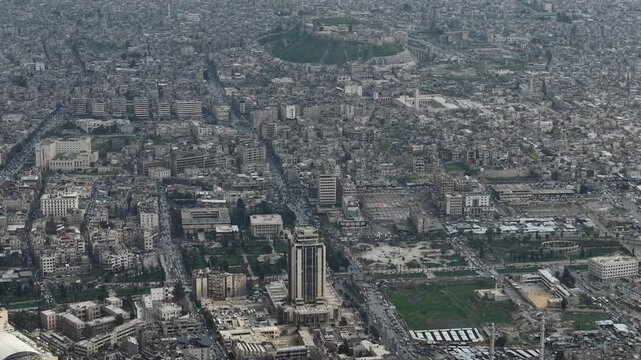 Drone view of a city landscape in Aleppo, Syria. Urban skyline and residential neighborhoods from above. City streets, infrastructure, and middle eastern architecture.