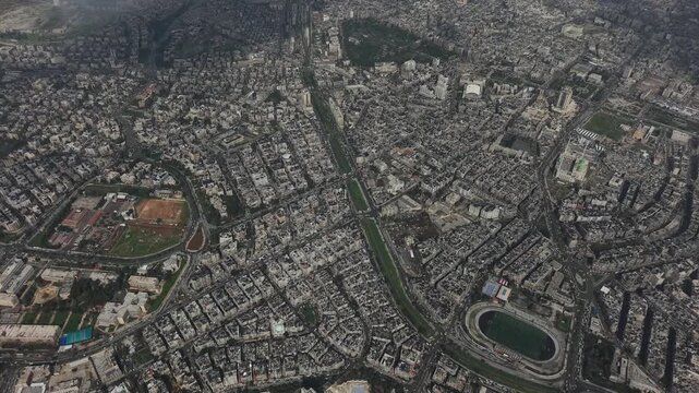 Drone view of a city landscape in Aleppo, Syria. Urban skyline and residential neighborhoods from above. City streets, infrastructure, and middle eastern architecture.