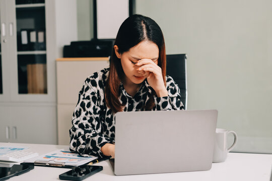Tried young Asian office employee feeling sick and have a headache from a long working day at office