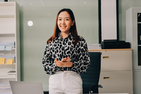 Confident asian business woman standing in modern office