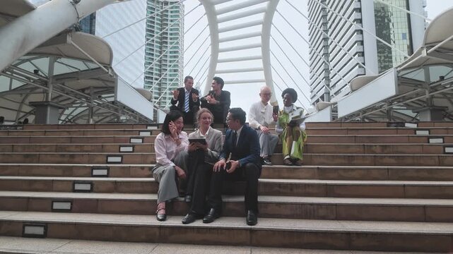 Team of professionals working together in a contemporary city setting with tall buildings in the background
