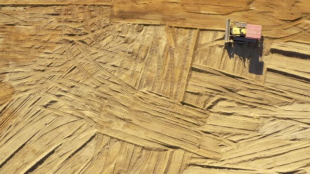 Drone, construction site and building with vehicle on sand, architecture and outdoor landscape. Contractor, maintenance or labor for infrastructure, aerial view of excavator and soil with real estate