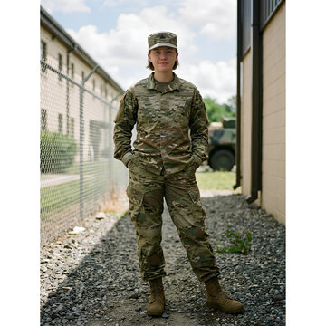 Female soldier in camouflage uniform standing at military base