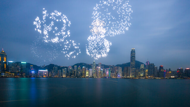 Spectacular colorful fireworks exploding over the Hong Kong cityscape at night.