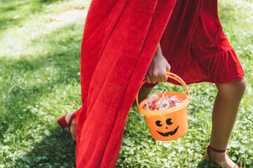 Naklejka premium Exciting trick or treating adventure on a spooky Halloween day, kid with bucket of candies 