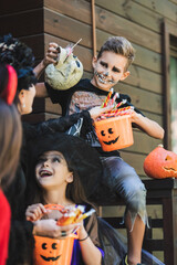 Fototapeta premium Happy family enjoying Halloween fun in costumes while trick or treating