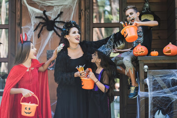 Fototapeta premium Family joyfully celebrates Halloween while trick-or-treating nearby