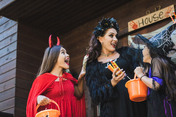 Fototapeta premium Family enjoys Halloween joy near a decorated house while trick or treating