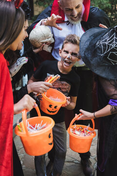Happy family costumes enjoying fun trick or treating celebration outdoors