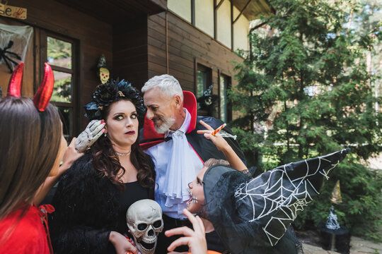 Happy family enjoying Halloween festivities while trick or treating outdoors
