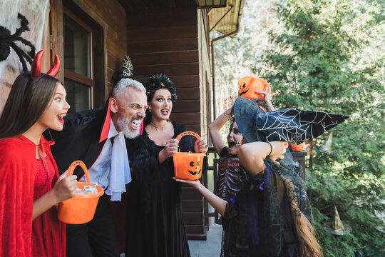 Joyful family celebrating Halloween together with costumes and treats