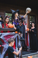Fototapeta premium Family enjoying Halloween fun with costumes and decorations at a cozy cottage