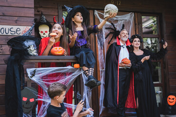 Fototapeta premium Family celebrates Halloween with costumes and treats at home