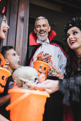 Fototapeta premium Joyful family enjoying Halloween fun with costumes at their cozy decorated home