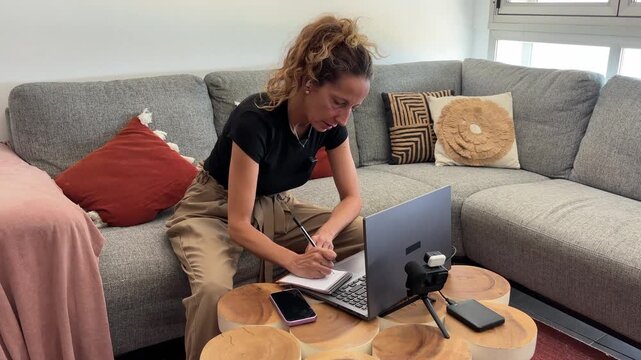 Mujer pasando contenido de c&aacute;mara al ordenador port&aacute;til