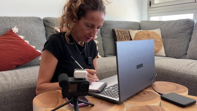 Mujer pasando contenido de c&aacute;mara al ordenador port&aacute;til