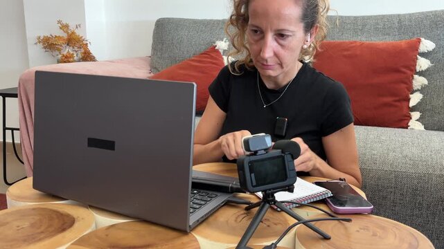 Mujer pasando contenido de c&aacute;mara al ordenador port&aacute;til