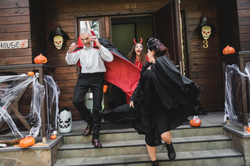 Fototapeta premium Family has Halloween fun trick-or-treating by a spooky house
