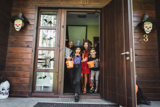 Family enjoys Halloween fun while trick or treating by their spooky cottage
