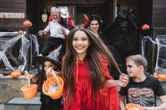 Happy family enjoying Halloween with costumes and decorations at cottage