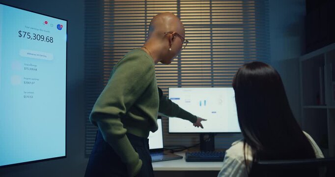 Young Asian businesswomen team meeting work on laptop at office night. Corporate teamwork collaboration, financial report analysis, strategy project planning, colleague development support concept.