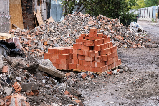 Stacked red bricks on pallet at demolition site