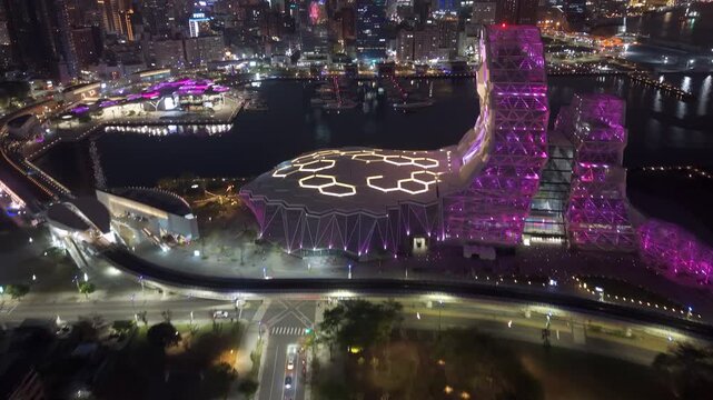 Aerial tilt up shot revealing the Kaohsiung City harbor and skyline at night in southern Taiwan.	