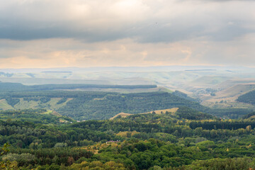 Fototapeta premium Layers of green mountains and hills in the haze during sunset. Panoramic View of Green hills and Meadow.