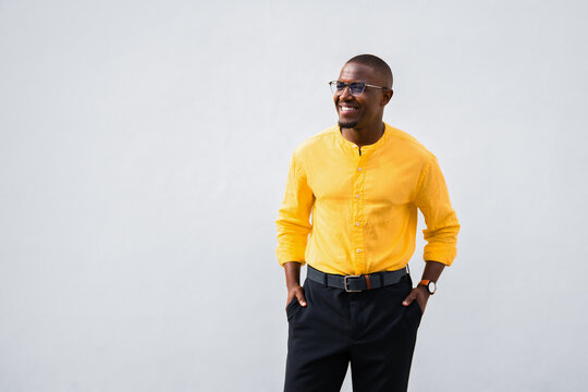 African american man, businessman entrepreneur looking aside with hands in pockets, standing relaxed, confident consultant in professional casual isolated studio business portrait with copy space for