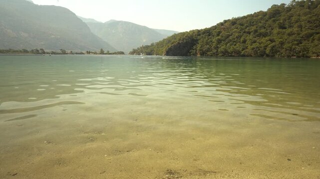 Crystal Clear Water on Sandy Shore, Sunlight Reflections