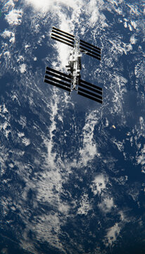 A manned orbital station orbiting earth with solar panels and clouds