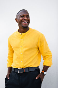 Laughing and looking up, african american man, businessman poses in vertical casual isolated studio business portrait. Joyful young coach shows energetic, smiling expression and natural charisma when