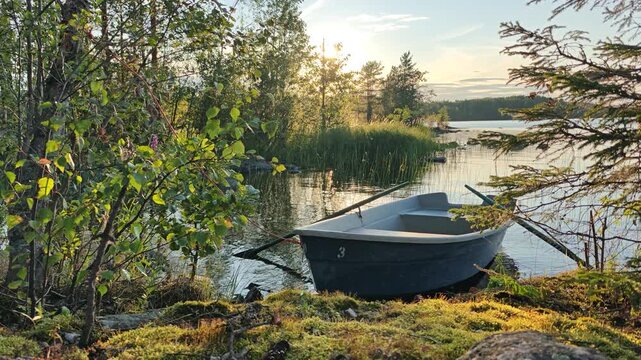 a boat on the lake shore at sunset